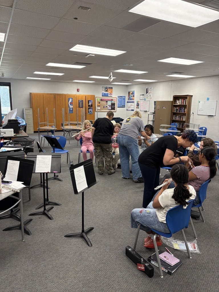 adults showing students how to hold flutes