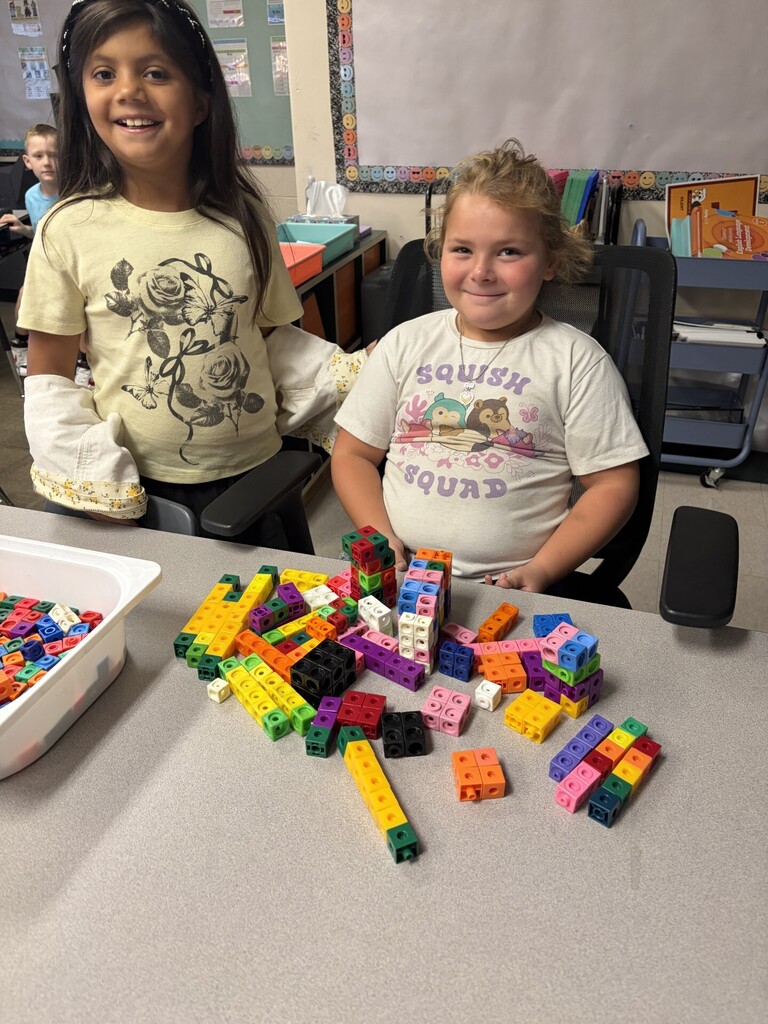 Two girls are playing with blocks.