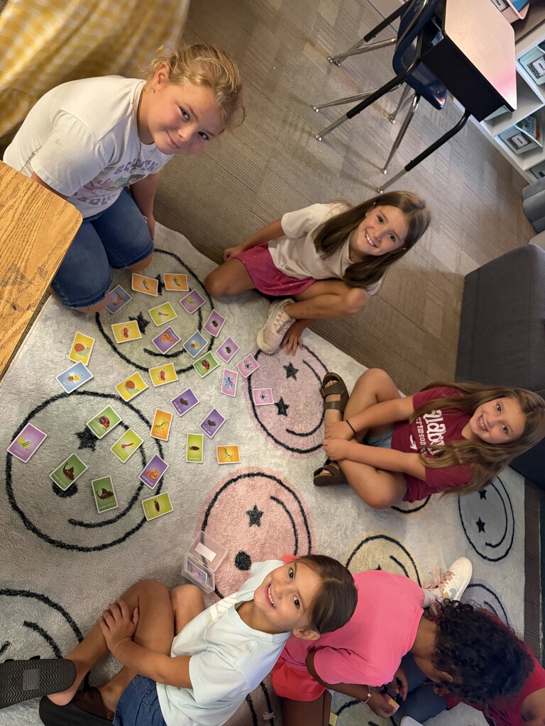 A small group of girls are playing a matching cards game.