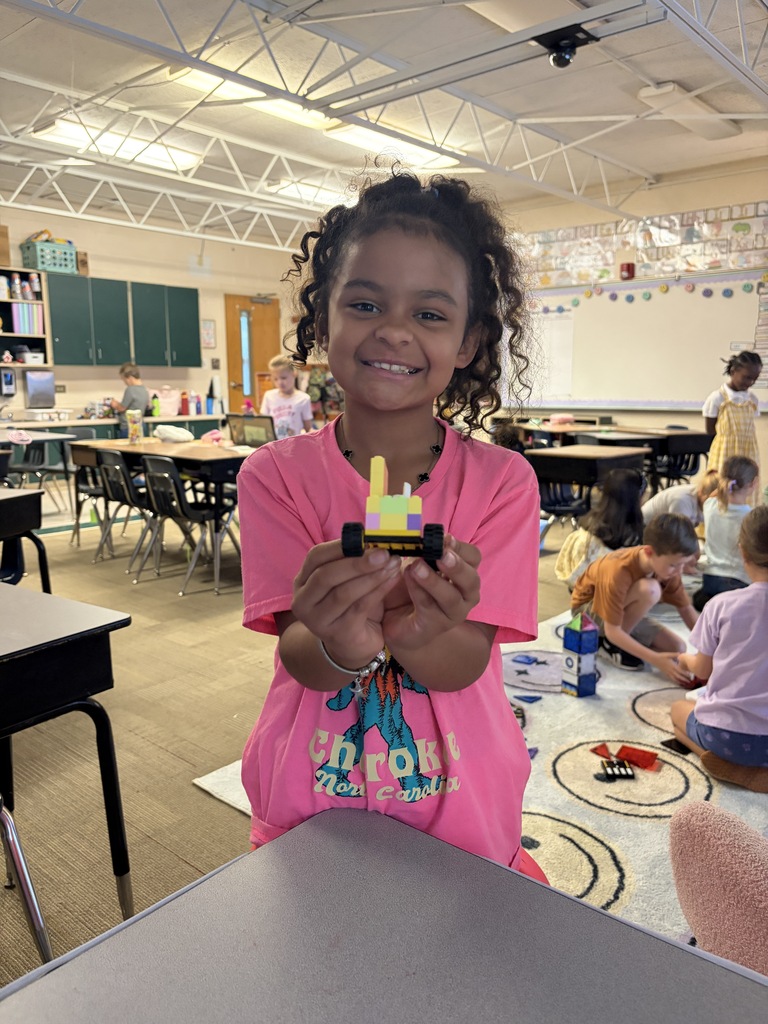 A girl shows off what she built with Lego blocks.
