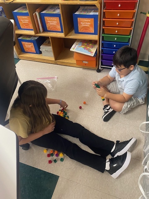 Two students are using blocks to practice math skills.