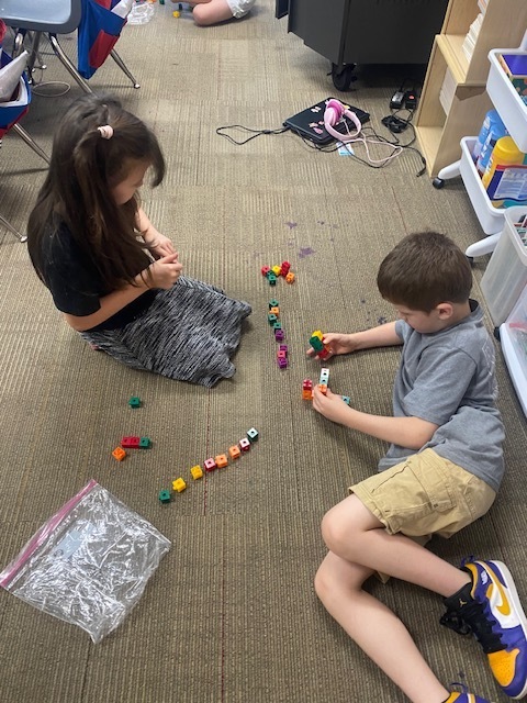 Two students are using blocks to practice math skills.