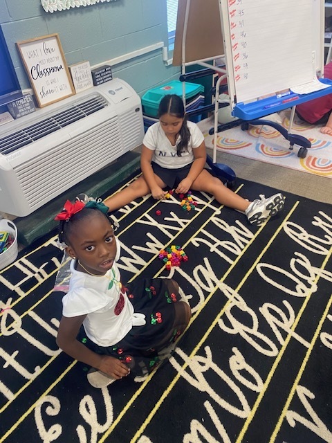 Two girls are using blocks to practice math skills.