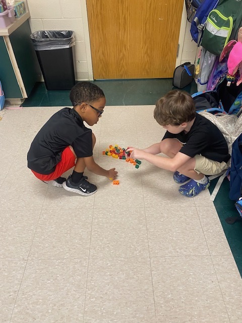 Two boys are using blocks to practice math skills.