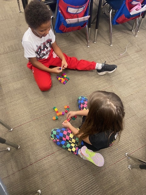 Two students are using blocks to practice math skills.