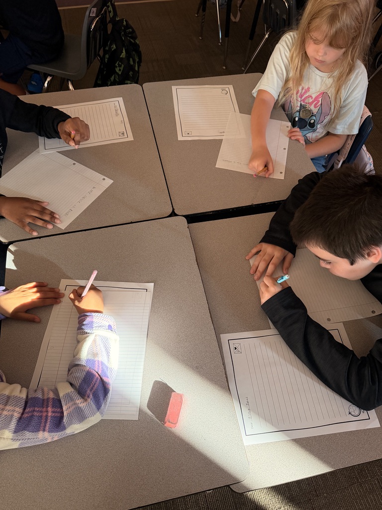 Four students are writing at their desks.