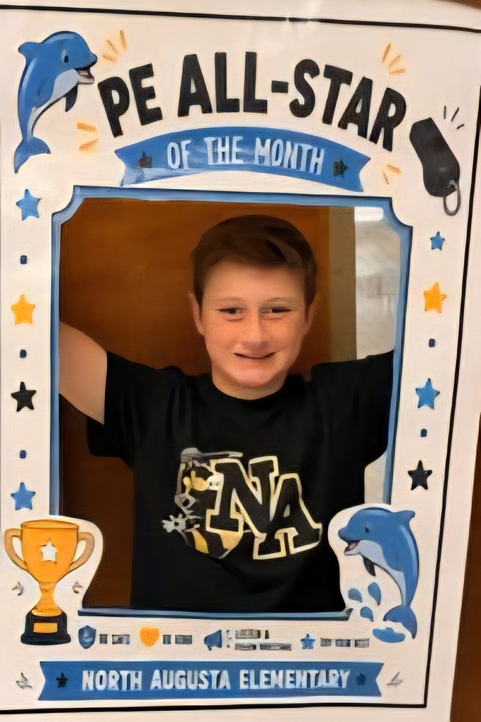 A young boy stands in a photo booth frame with "PE All-Star of the Month" text, holding a trophy and smiling.