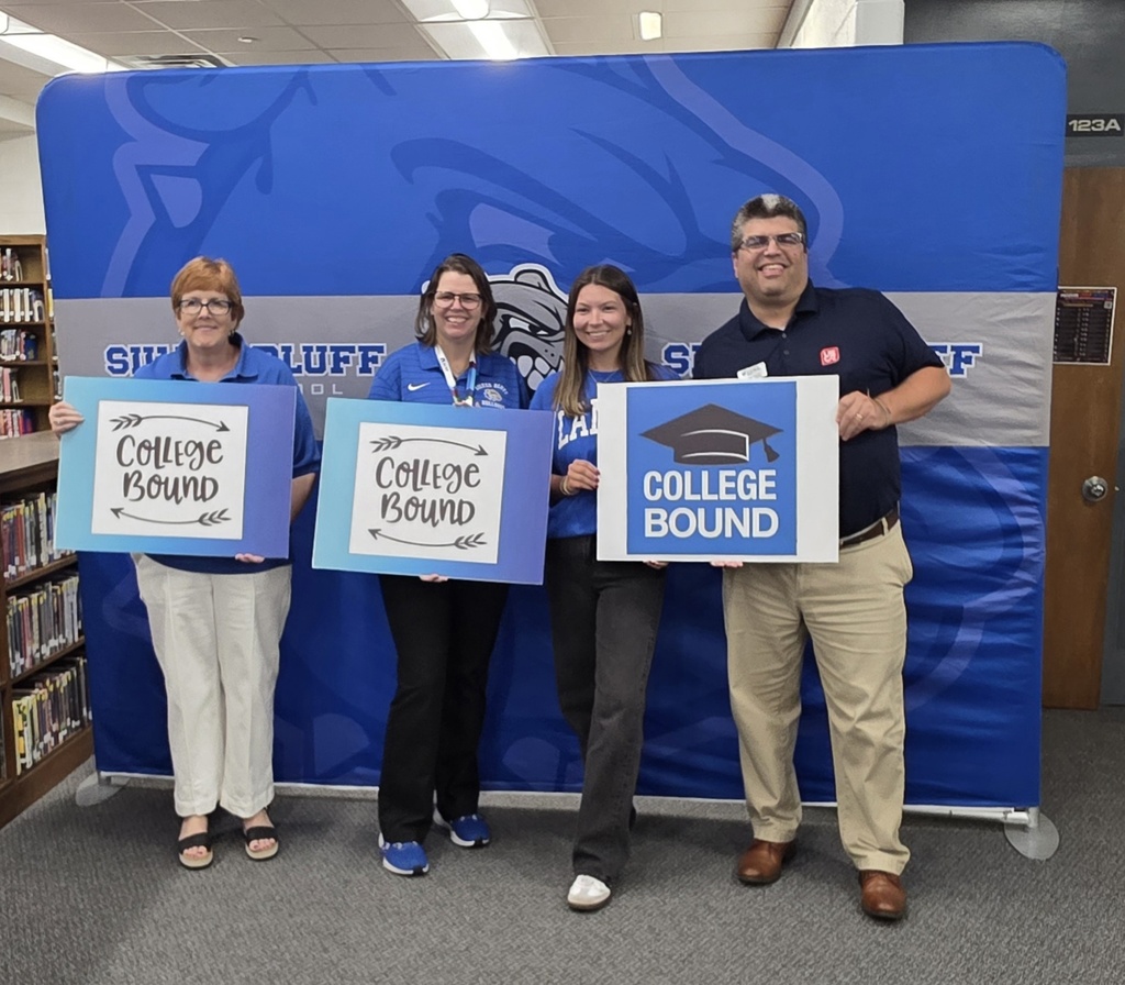 College Representatives and Dr. Kolmar holding college signs
