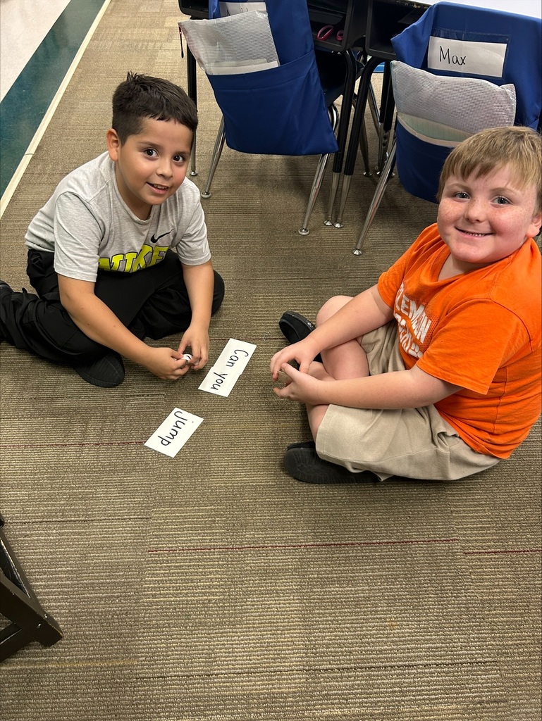 Two boys are placing word flash cards into sentence order.
