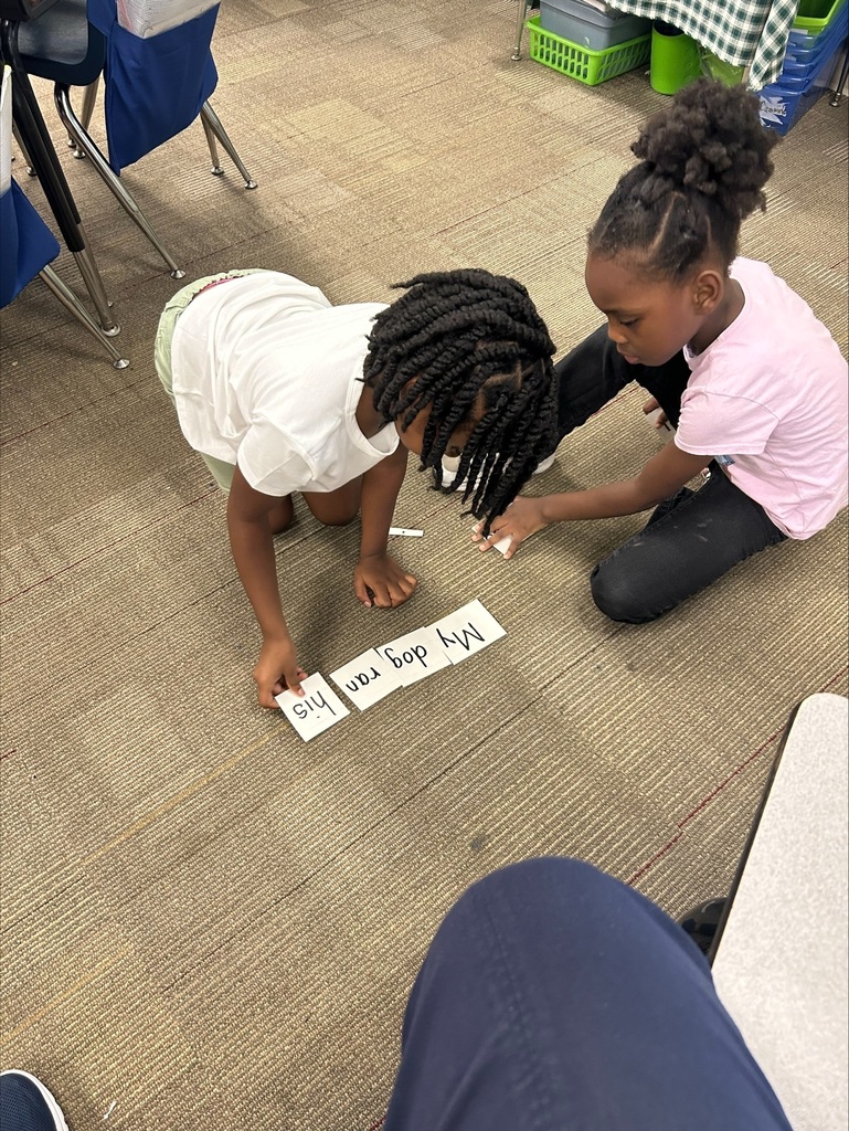 Two students are placing word flash cards into in sentence order.