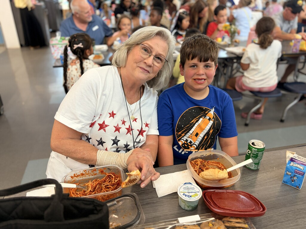 Woman and child having lunch and smiling at the camera