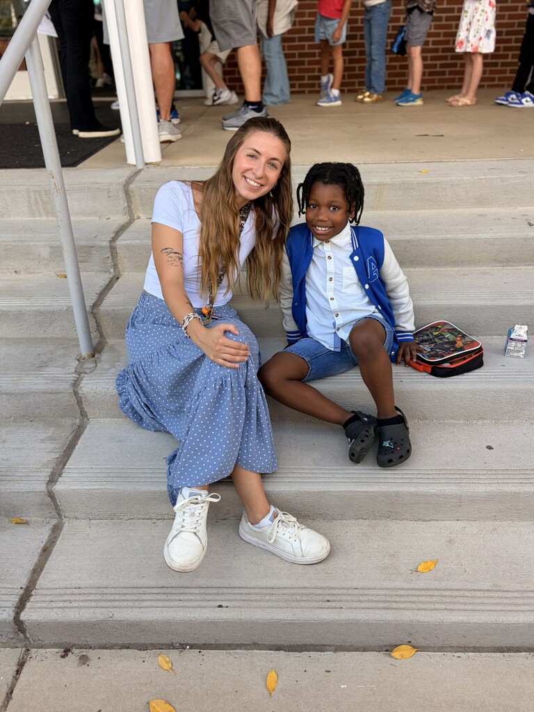 Woman and young boy sitting on steps and smiling at the camera
