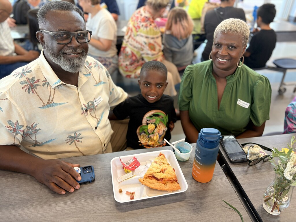 Two adults and child having lunch together