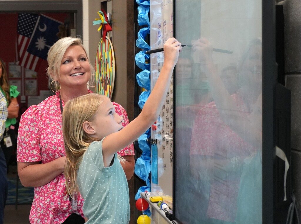 Amy Hadden watches a student work on the smart board. 