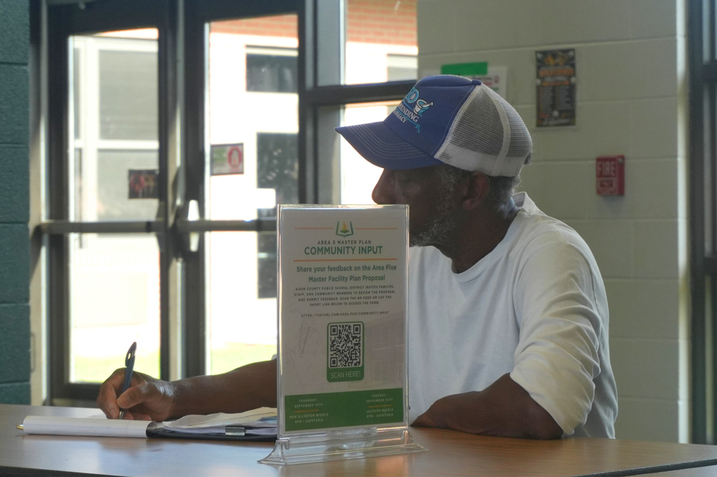 Male community member sitting and completing survey for the input meeting.