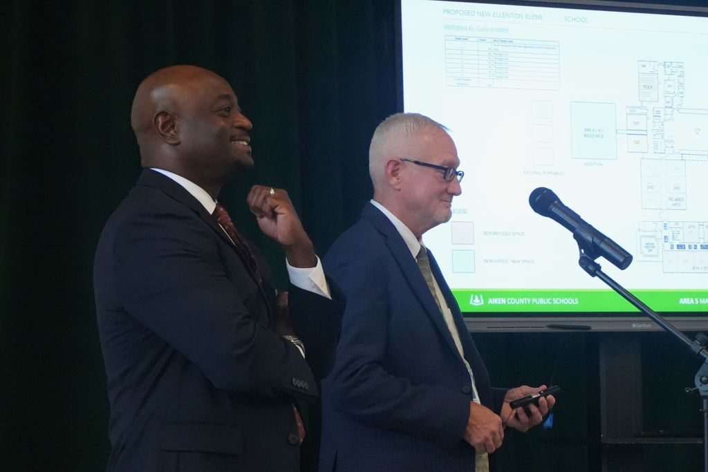 Superintendent smiling while at podium during presentation.