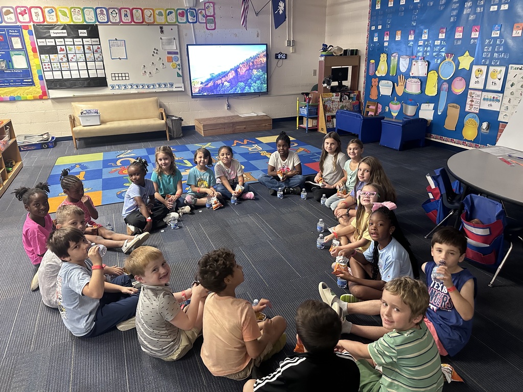Students are sitting in a circle on the floor.