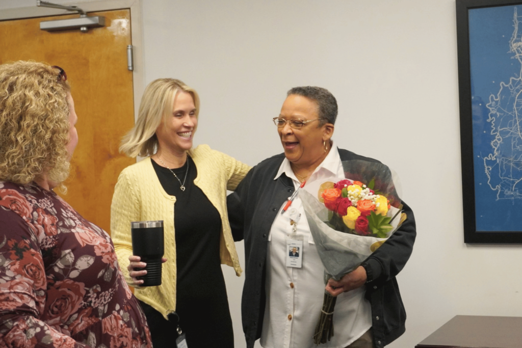 HR employee smiling while being surprised with being employee of the month.