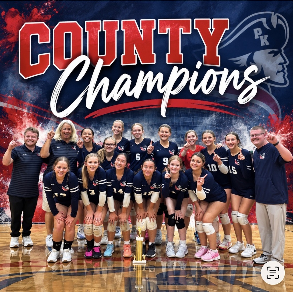 A team of female volleyball players in blue uniforms stands on a court with a trophy.