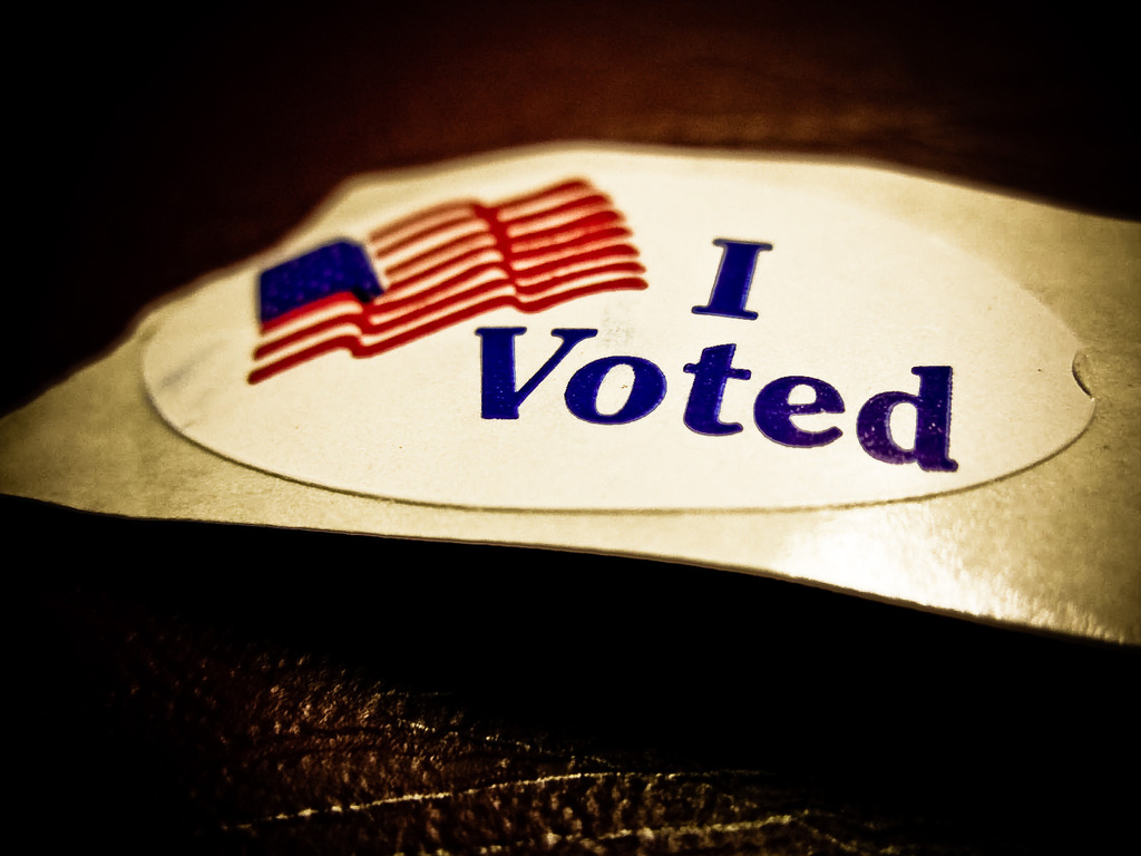 A sticker with "I Voted" and an American flag image on a dark background.