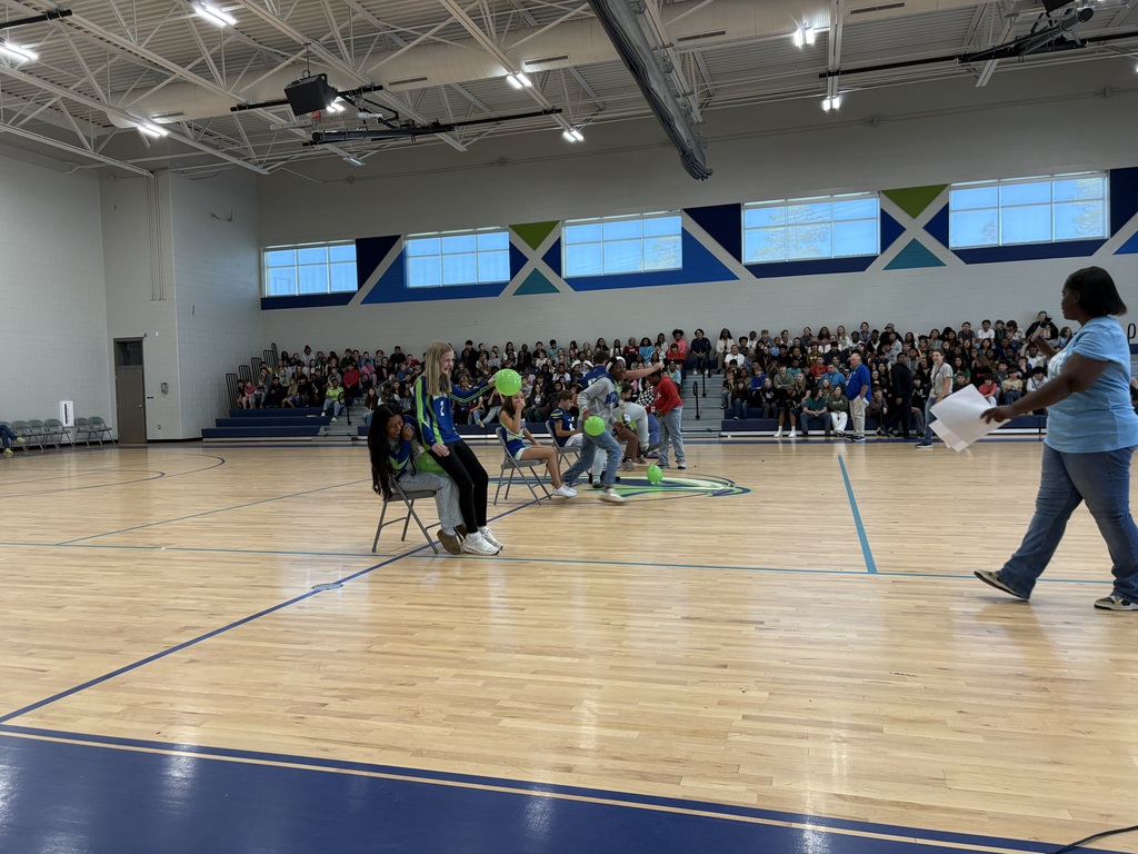 Students and teachers play pop a balloon game at pep rally