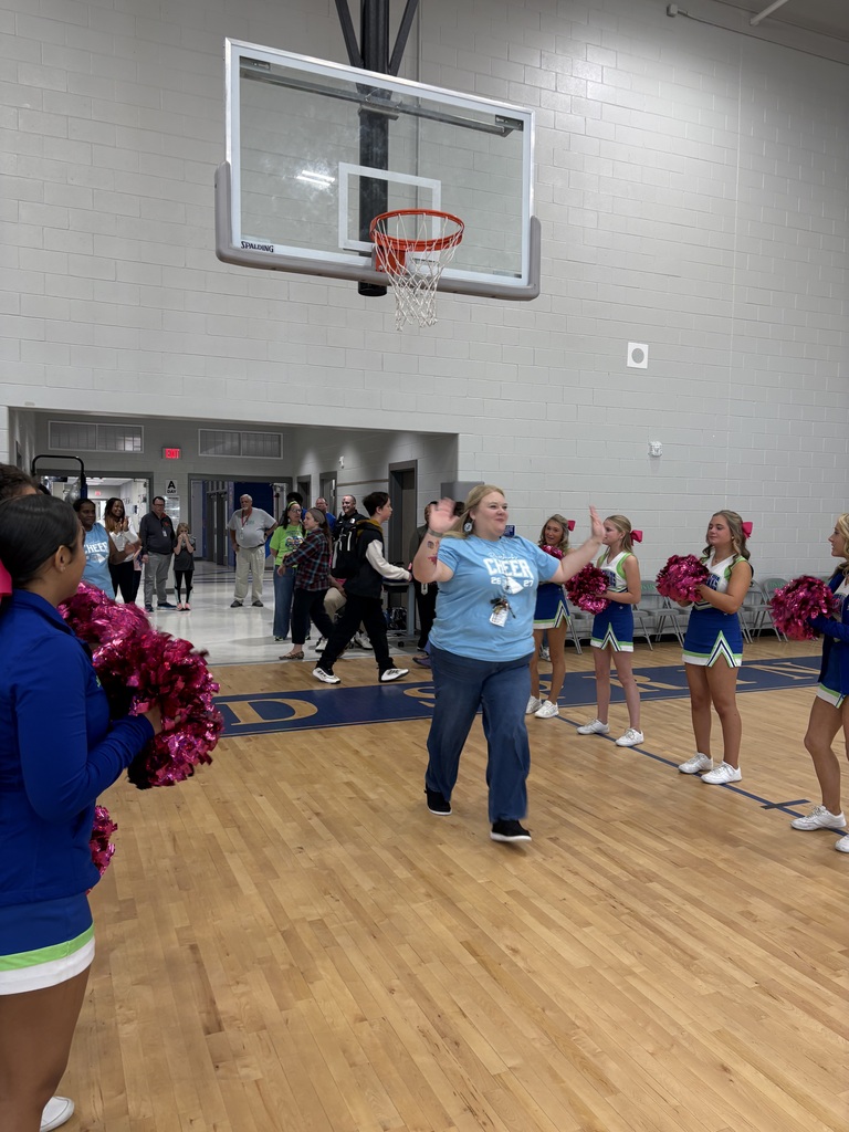 School faculty showing off tattoos at pep rally