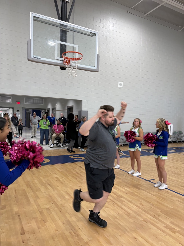 School faculty showing off tattoos at pep rally