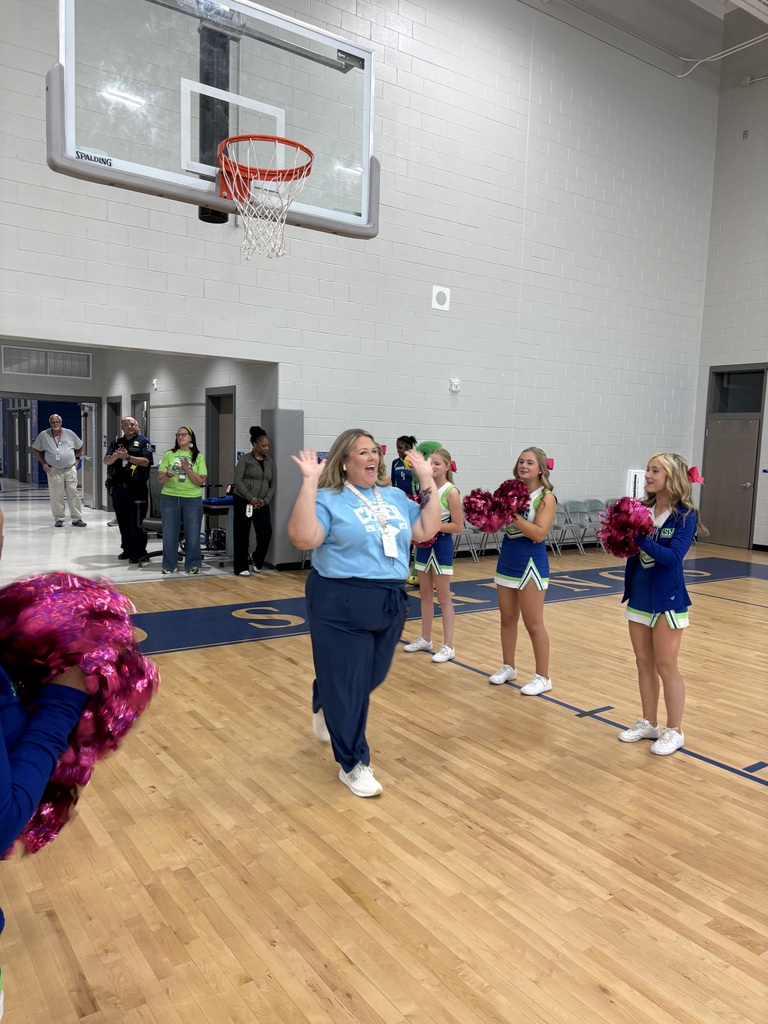 School faculty showing off tattoos at pep rally
