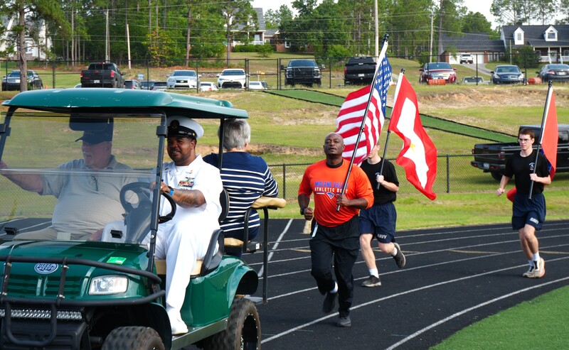 Dr. Corey Murphy follows behind a golf cart holding the Dillion Family and is followed by two NJORTC cadets.