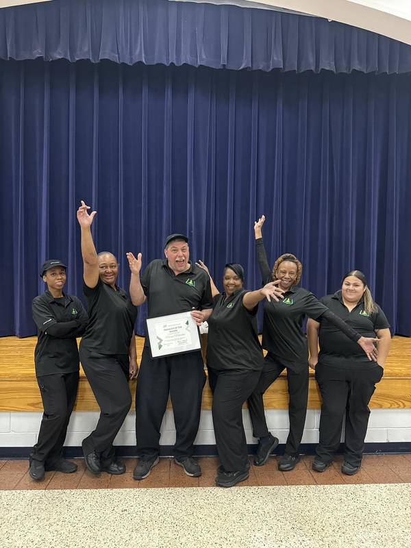 Child Nutrition Manager Michael Marcelain stands with Schofield's Child Nutrition Team for a Picture