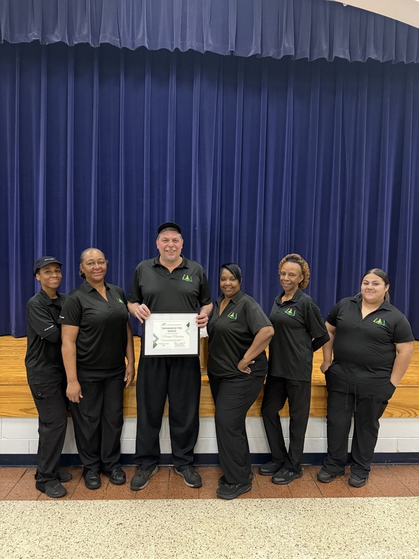 Child Nutrition Manager Michael Marcelain stands with Schofield's Child Nutrition Team for a Picture