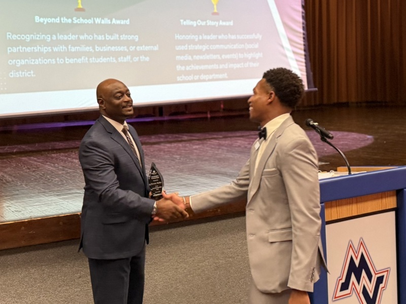 An assistant principal goes to accept his award.