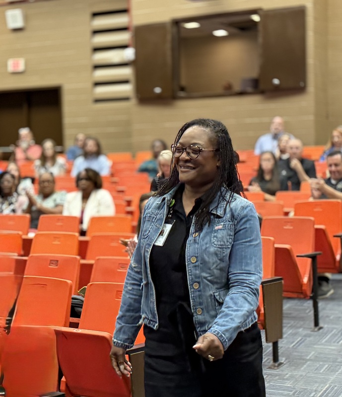 A principal walks to accept her award.