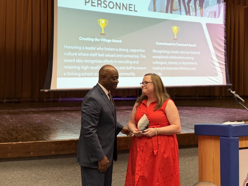 An award is given to an elementary school principal.