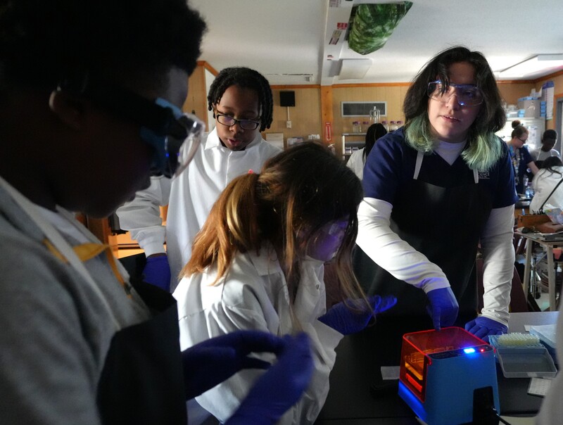 Biomedical students gather while looking at equipment.