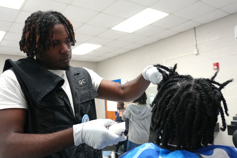 A student practices barbering.