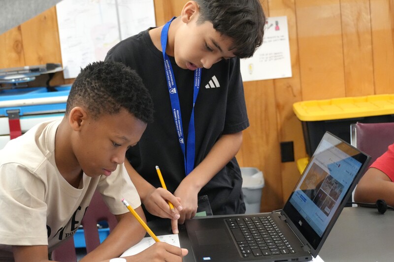 Two students practice planning a trip.