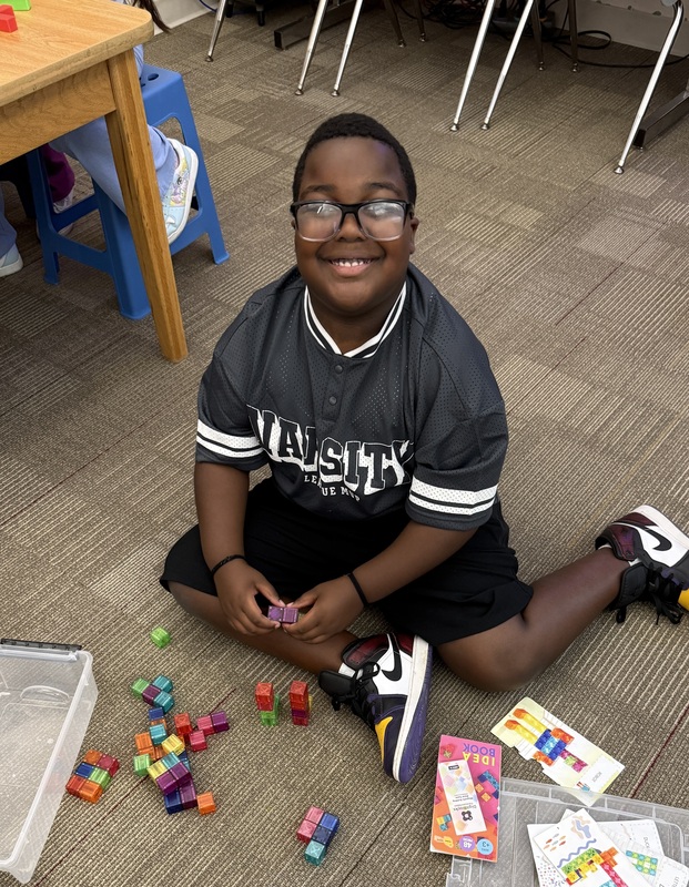 A boy playing with magnetic cubes.