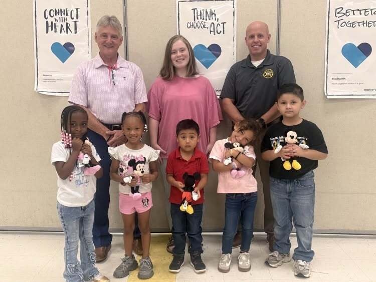 Students posing for a picture with their stuffed animals.