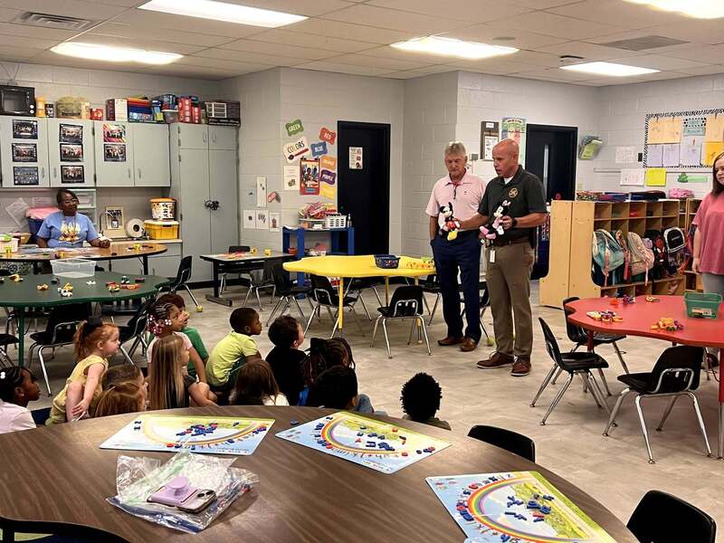 Officers presenting stuffed animals to the class.
