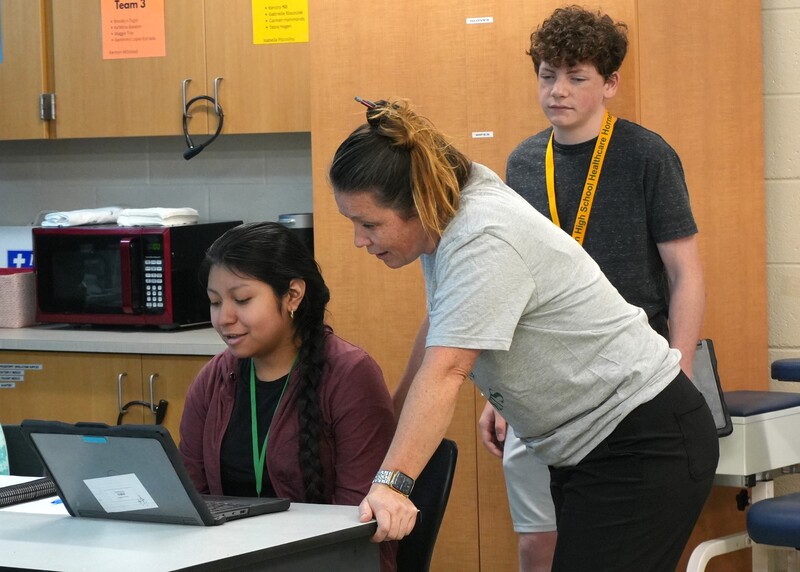 Kristy Ghrist helps a student on her laptop.