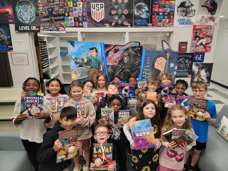 Group of students holding new books