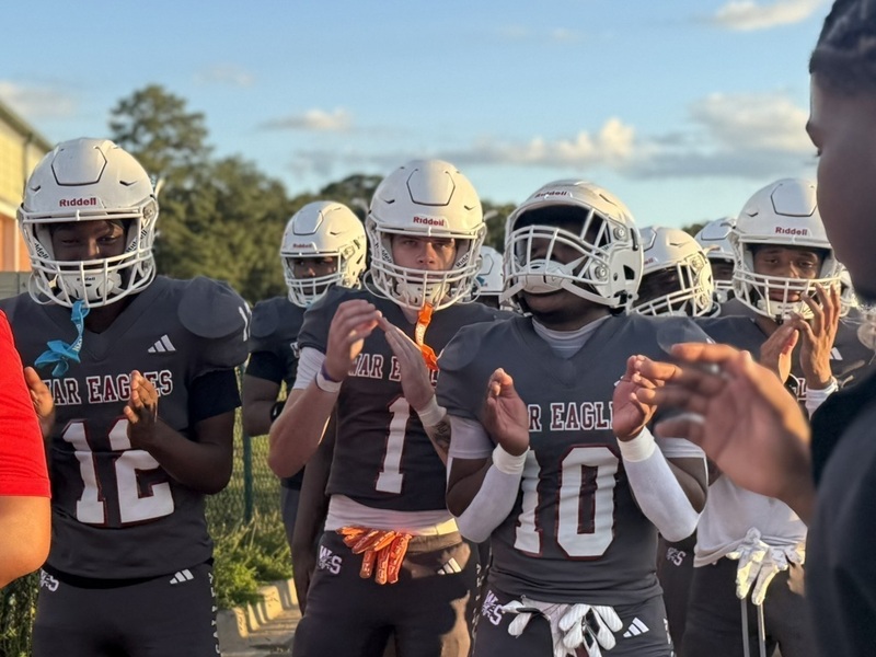 Wagener-Salley football players clap before kickoff.