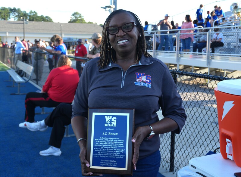 Deborah Tyler, school board member, holds up plaque.