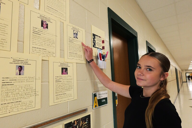 Aiken High student pointing toward her contribution to the 9/11 memorial wall.