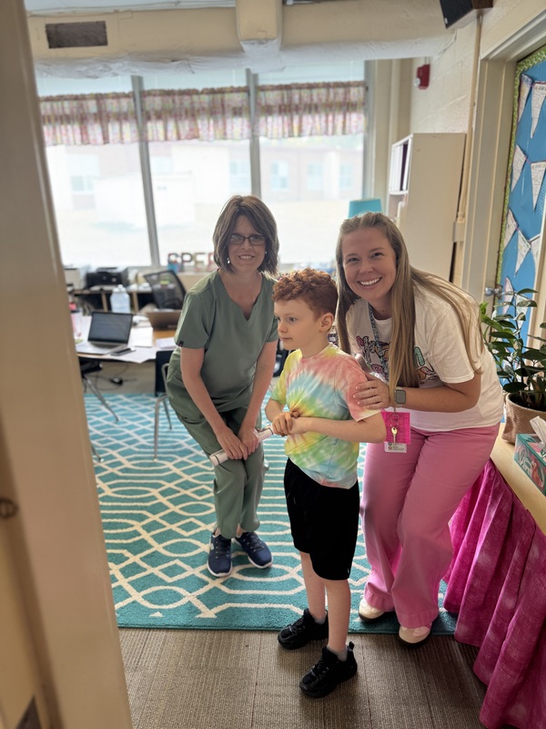 Two women stand with a boy.