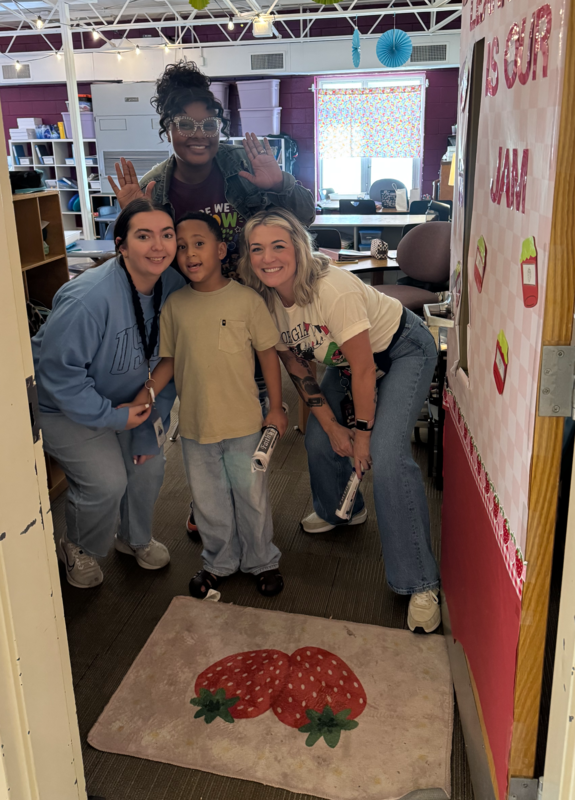 Three teachers stand around a student.