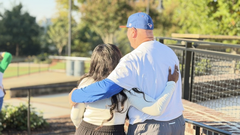 Two people hug.