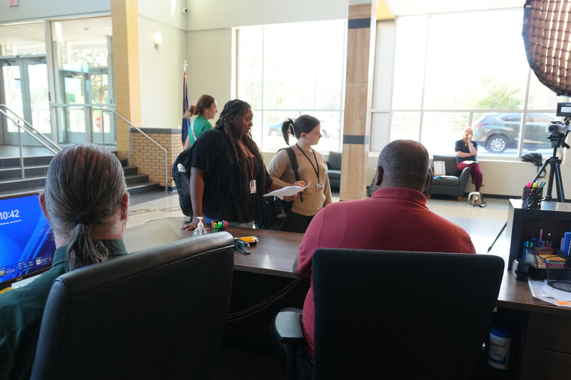 Two students practicing lines in front of camera in the front office.