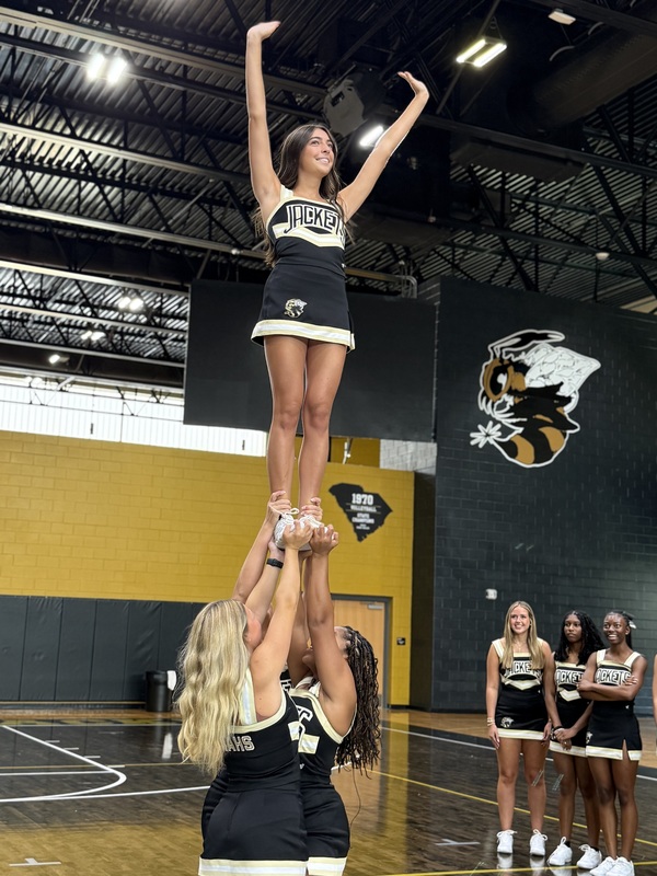 North Augusta High Cheerleaders practice in school gym.